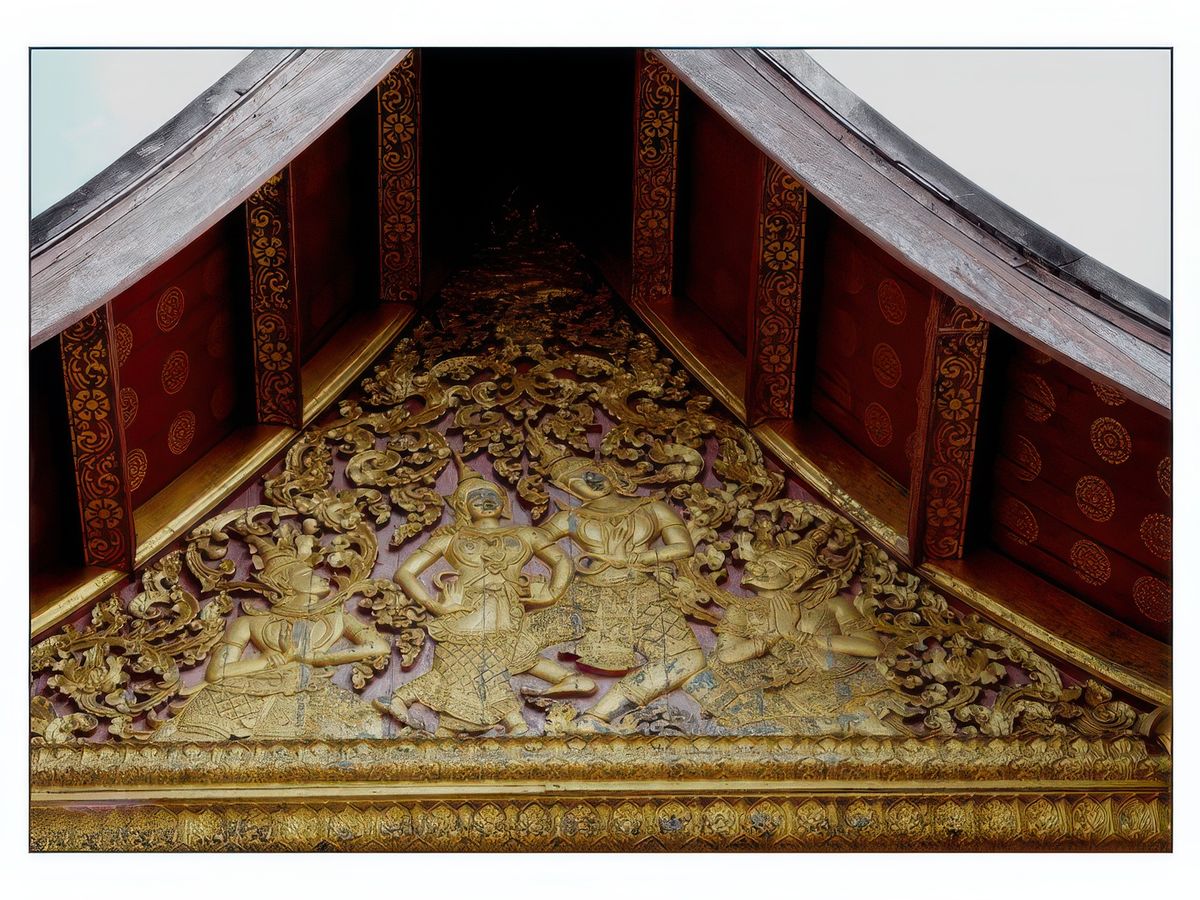 Sculptures dorées sur bois sous la toiture.