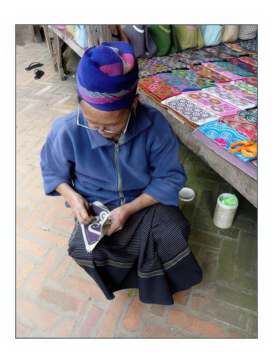 Grand-mère Hmong brodant de jolies pochettes.
