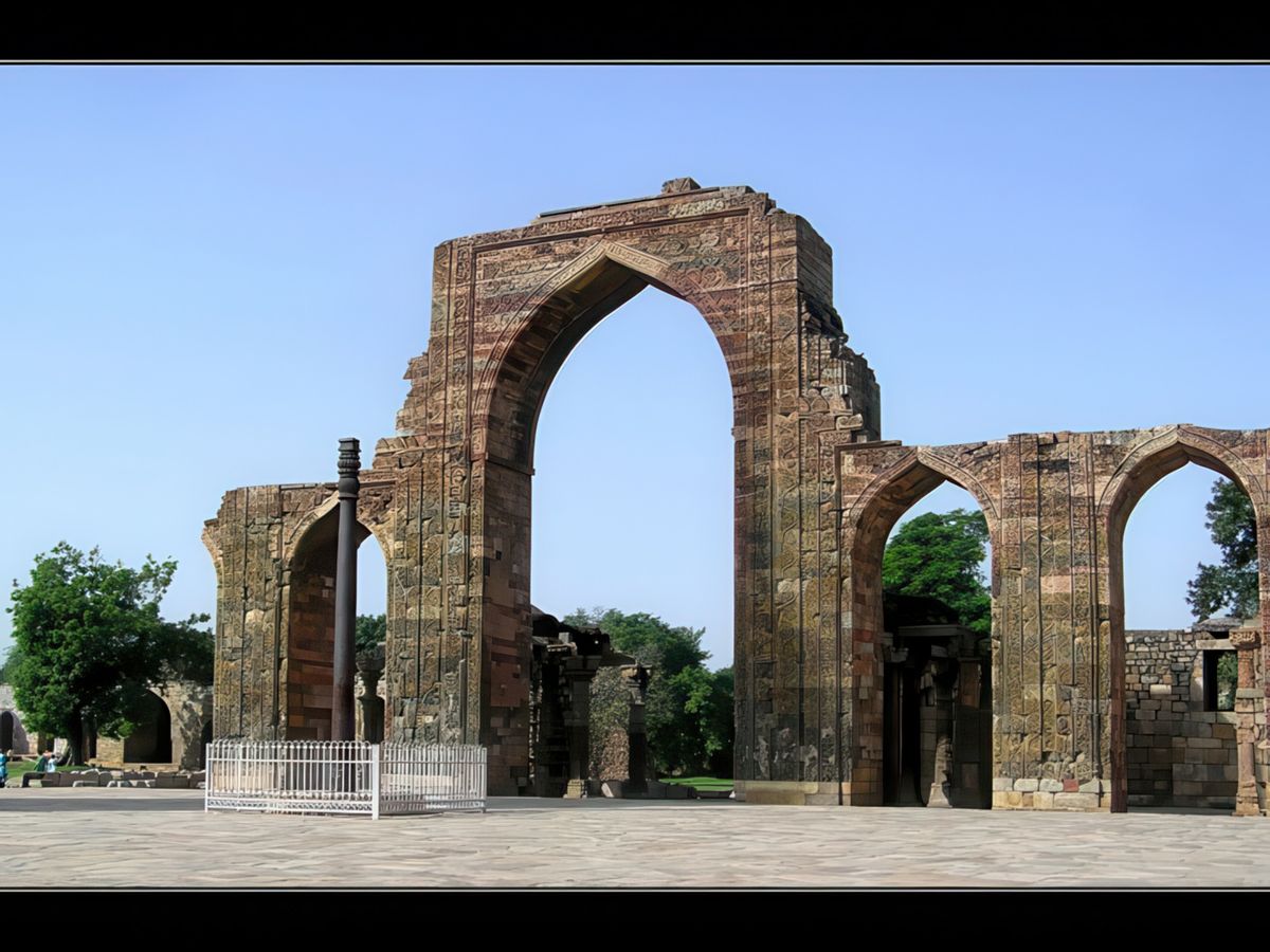 La porte en grés Alai Dawoza et devant sur la gauche le Pilier de Fer, seul élément hindou du complexe laissé intact et érigé au IVe siècle. Il mesure 7 mètres de haut et pèse plus de 6 tonnes.