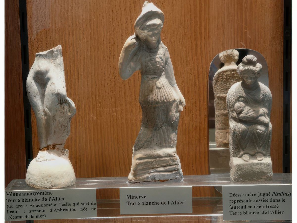 Figurines en terre blanche du centre de la Gaule. A gauche, Vénus anadyomène. Au centre,Minerve et à droite Déesse mère représentée assise dans un fauteuil en osier tressé.