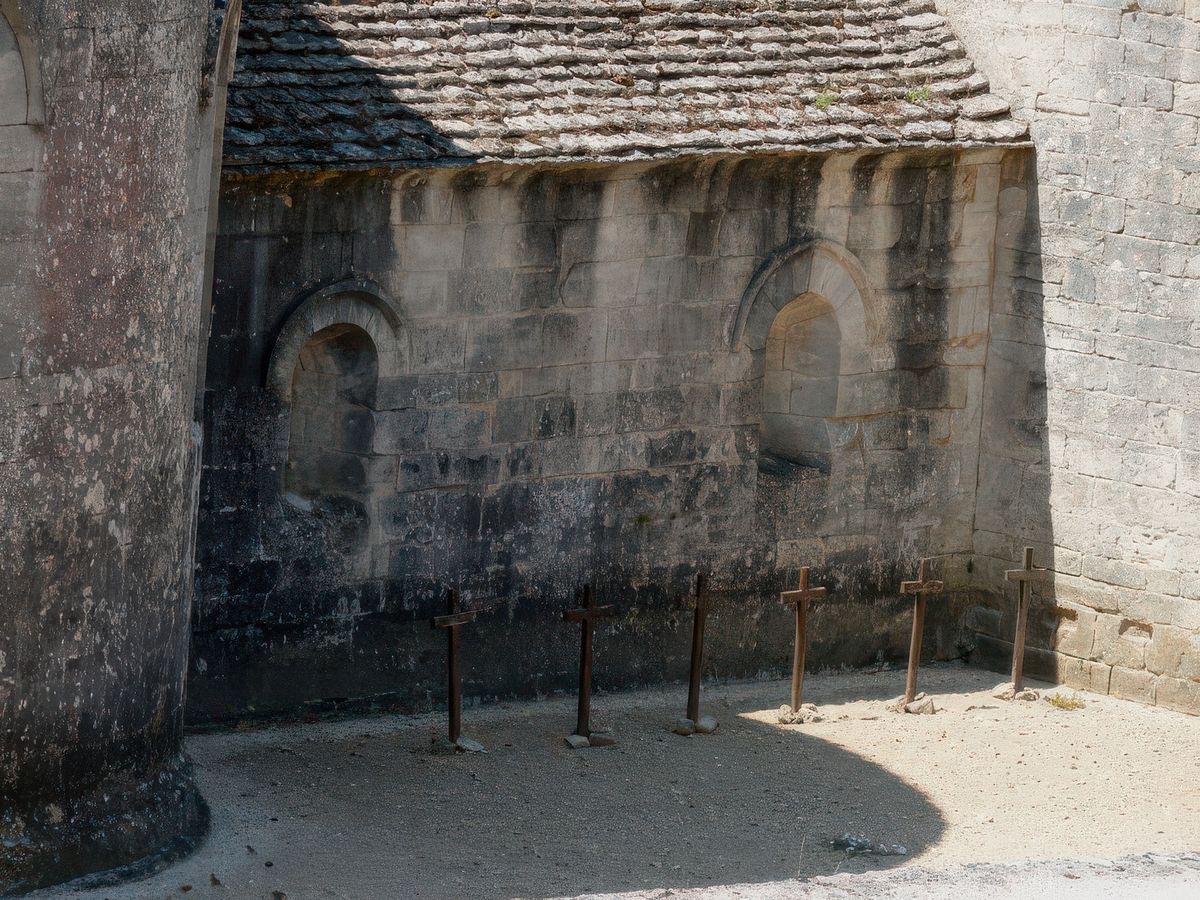 Six moines reposent à même la terre près du chevet de l'église abbatiale.