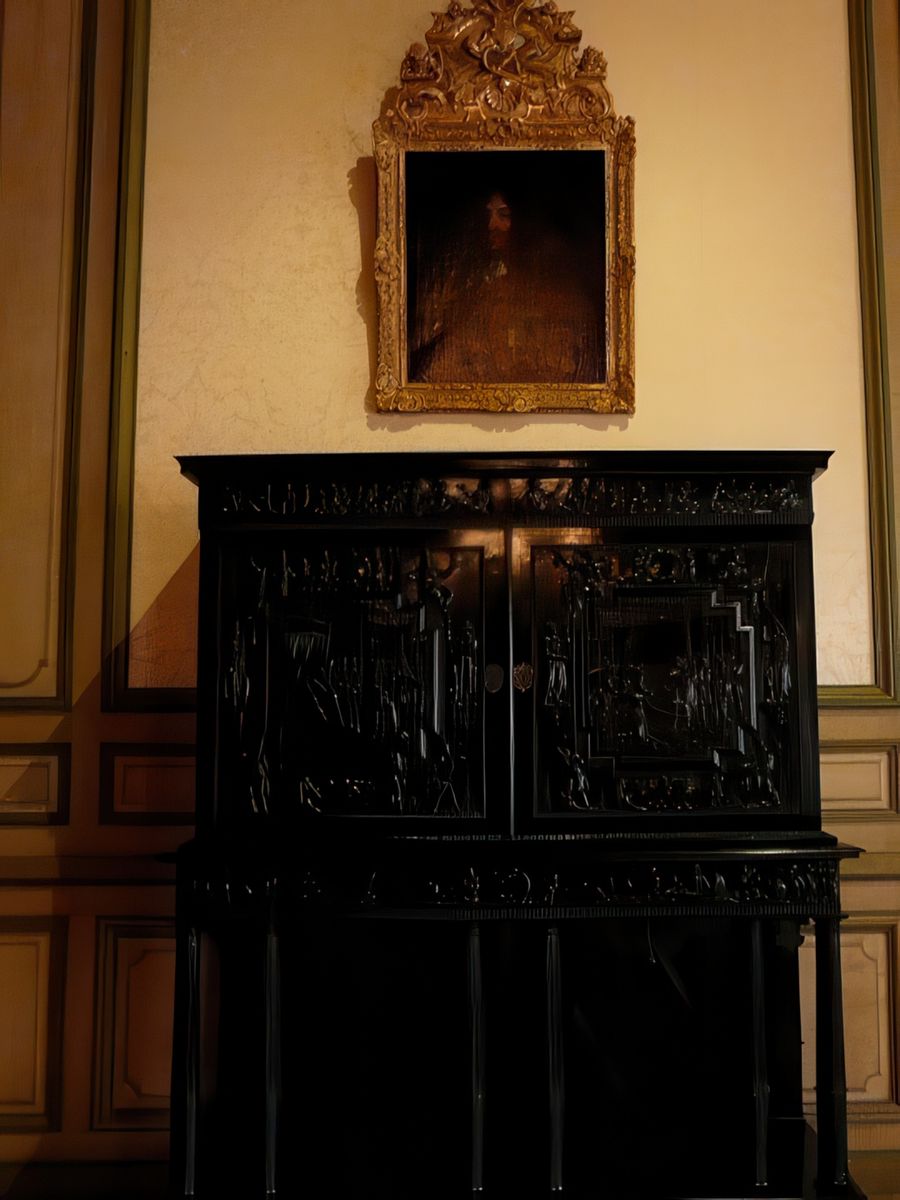 Portrait de Louis XIV, situé au-dessus d’un magnifique meuble d’apparat, le cabinet d’ébène.