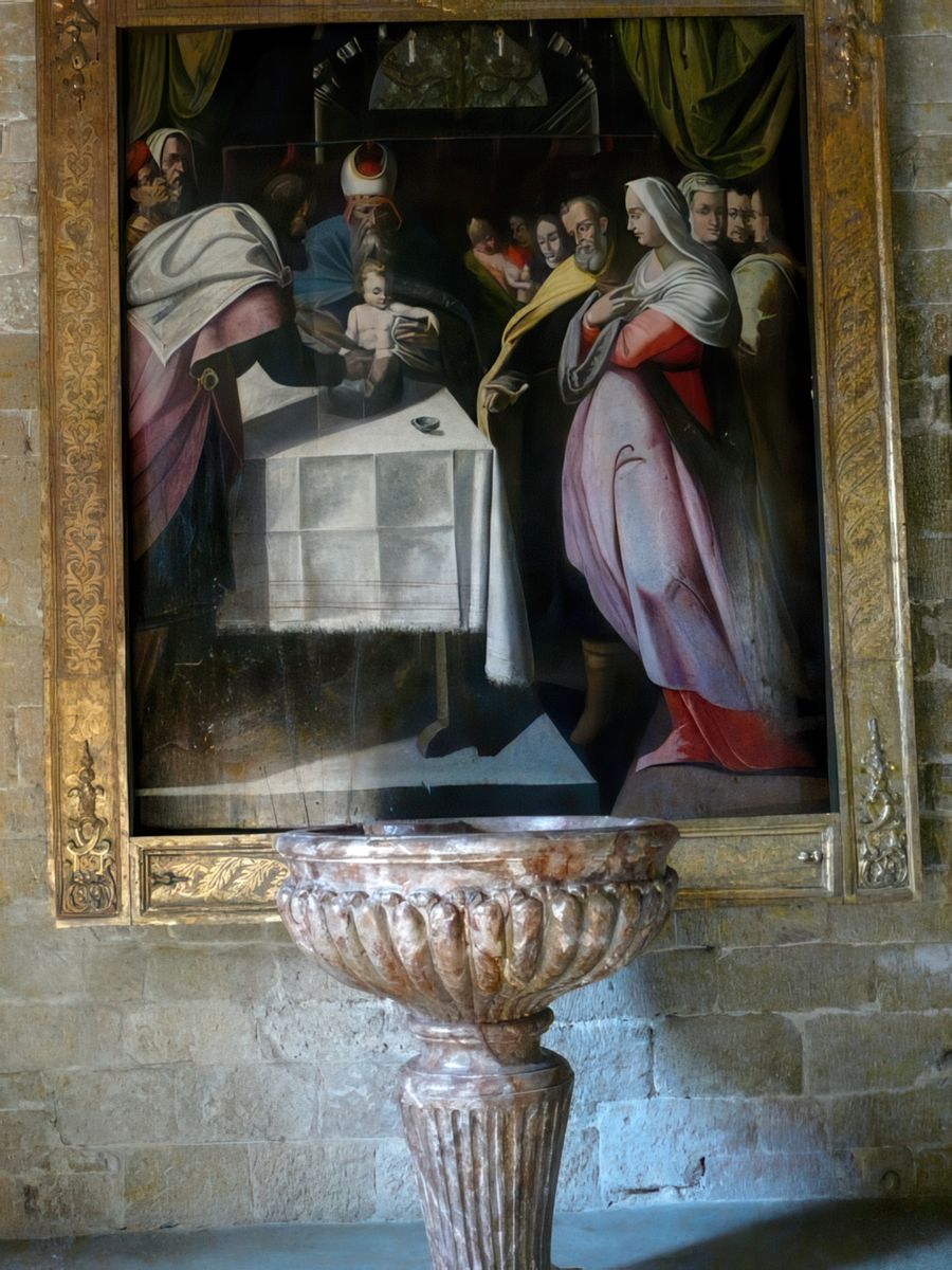 Les fonds baptismaux sont surmontés d'un des principaux trésors de l'église: une rare représentation de la Circoncision du Christ. Il s'agit d'une huile sur bois du XVIe ou XVIIe siècle, due à un peintre méridional d'inspiration flamande qui fait référence au maniérisme italien et nordique. Etait-il destiné à essayer de convertir la nombreuse communauté juive de la ville en leur rappelant cette pratique sacramentelle?