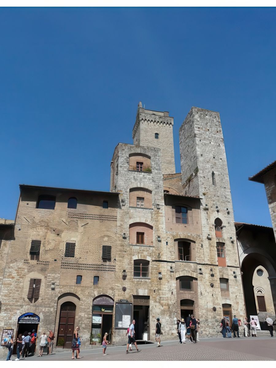 Au 1er plan, les 2 tours jumelles des Ardinghelli se situent sur la place de la Cisterna, à l'angle de la place du Duomo. Les Ardinghelli (guelfes), l'une des puissantes familles de San Gimignano, à l'instar de la famille rivale des Salvucci (gibelins), avaient fait ériger ces 2 tours qui s'élevaient plus haut que la tour du Podestà (la tour Rognosa), ce qui enfreignait la règlementation en vigueur dans la commune. Tout comme les Salvucci, les Ardinghelli entendaient ainsi montrer leur puissance et leur suprématie sur la ville. A l'arrière plan, la Tour Grossa.