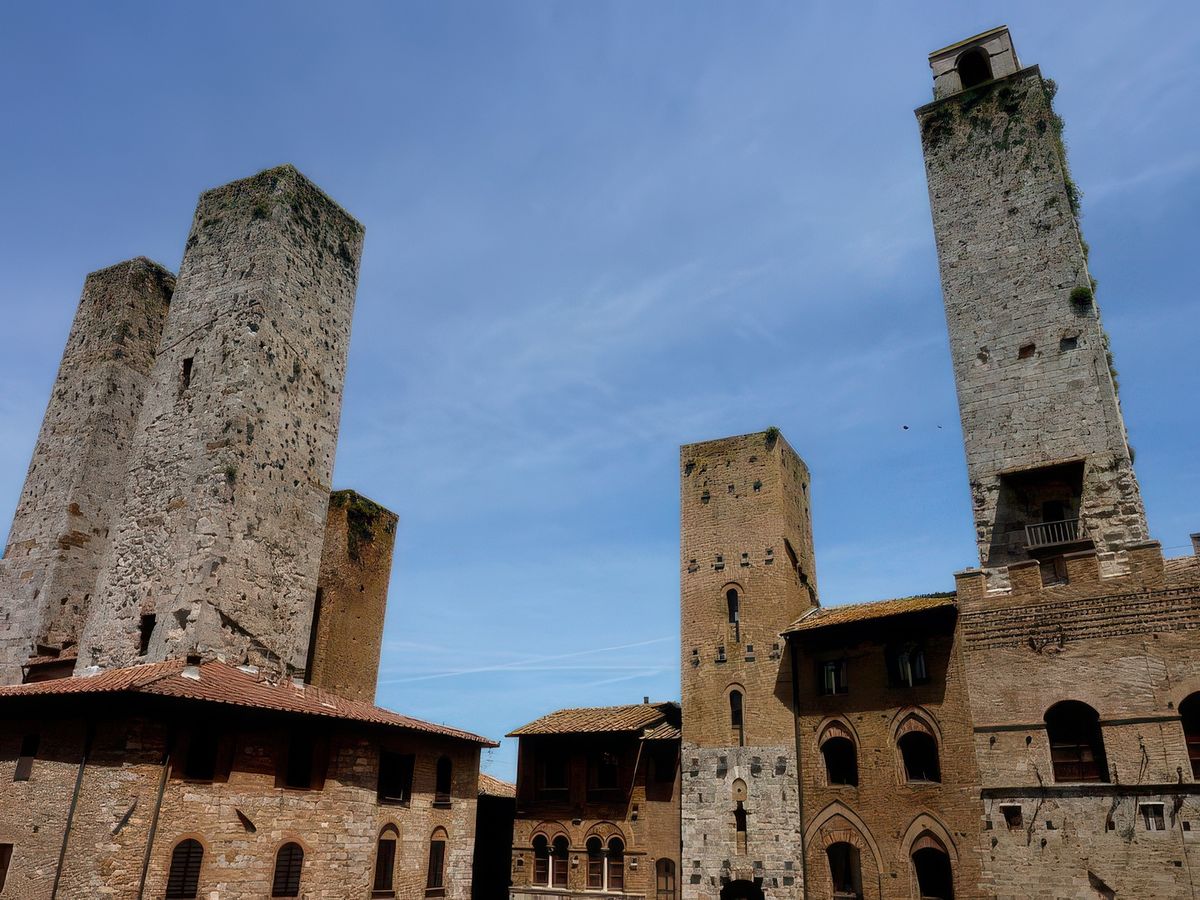 Une envolée de tours se dressent vers le ciel, gauche à droite: les Tours jumelles des Salvucci (51m), la Tour Pettini en brique rouge, la Tour Chigi, La Tour Rognosa, appelée aussi tour de l'Horloge, à son sommet, une cloche avertissait d'un éventuel danger. Son nom le plus courant, Rognosa, lui vient de ce qu'elle fut transformée en prison et fut donc fréquentée par des gens peu fréquentables, des "galeux", des "rognosi" en italien.