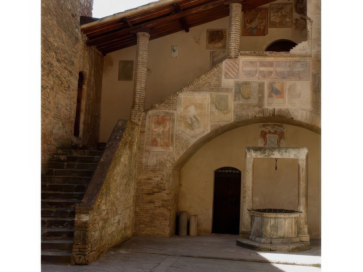 Le puits et l'escalier orné d'une série de blasons.