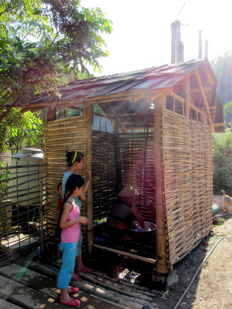 Promenade dans le village Cette cabine sert de douche et aussi de lavoir à toute la famille.