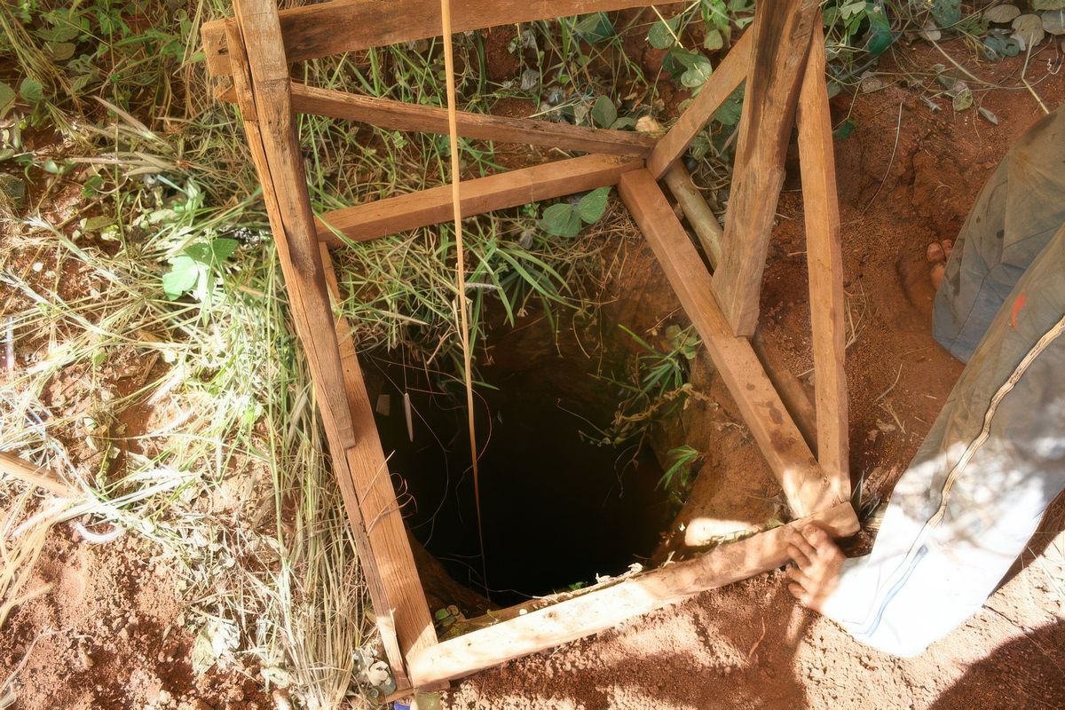 AU FOND DE CE TROU, A 30/40 M, SE TROUVE UN HOMME. SANS LUMIERE, SANS EAU POUR BOIRE, AVEC SEULEMENT UN PIQUE POUR CREUSER CETTE TERRE ROUGE, QUI REMONTERA PAR UN SEAU, ET PEUT ÊTRE UN ''TRESOR'' A L'INTERIEUR ???