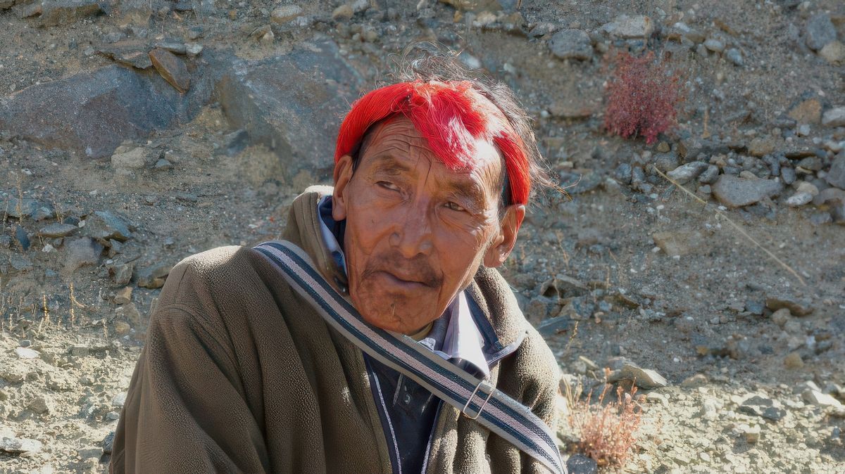 Pèlerin khampa, reconnaissable à sa coiffure rouge qui entoure sa tête.
