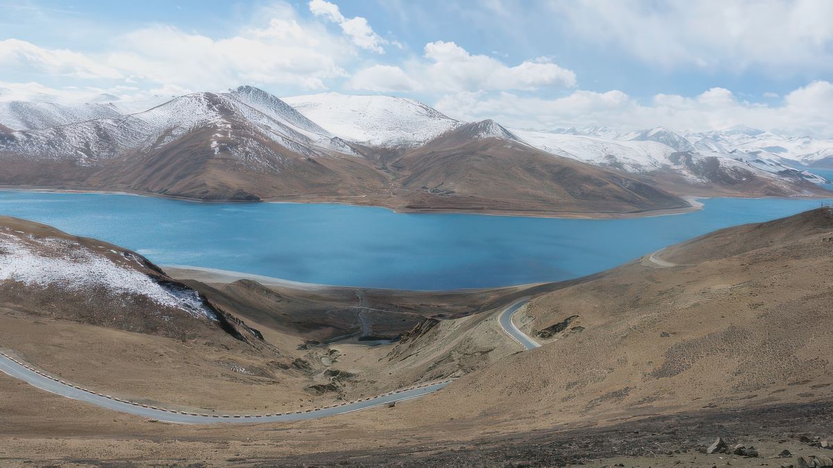 La route en lacets suit les contours du "Lac Turquoise" dont la forme étrange aux multiples bras le fait ressembler à un scorpion.