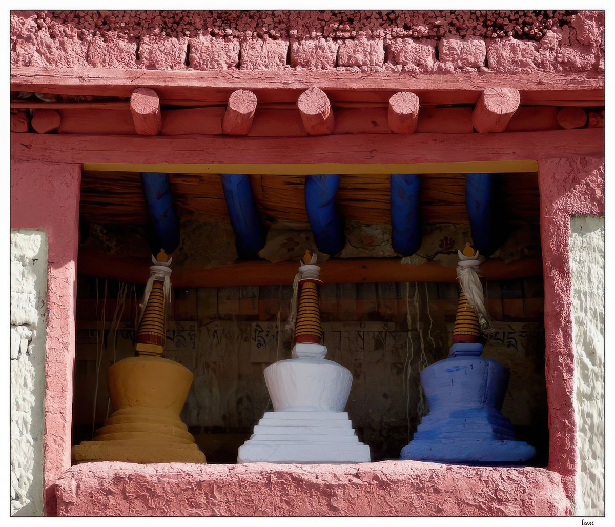 Trois jolis petits chörtens colorés sont exposés dans la cour: le jaune pour la sagesse, le blanc pour la compassion et le bleu pour la protection.
