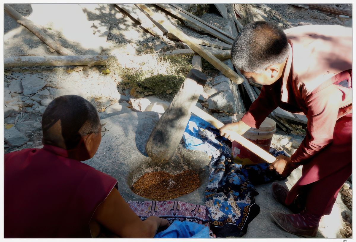 Une autre nonne est en train de piler les amandes; la nonnerie est entourée d'une véritable forêt d'abricotiers!