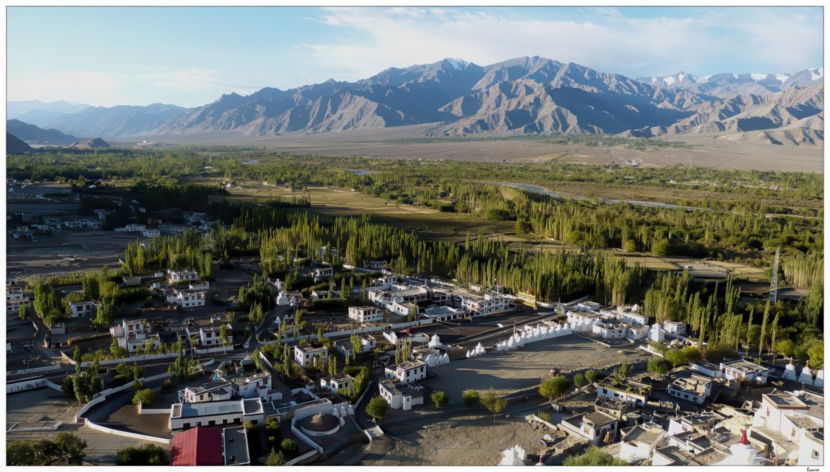Vue sur la vallée verte de l'Indus, parmi les vergers et les champs d'orge, l'aridité des montagnes et quelques sommets enneigés en arrière plan.