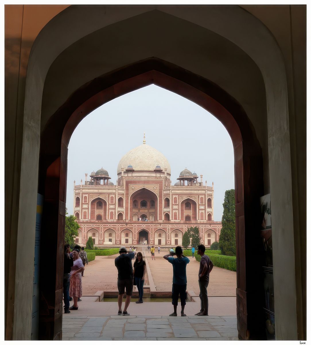 Vue sur sur le tombeau depuis l'entrée. Le tombeau de Humayun, dans lequel repose le deuxième empereur moghol, est un exemple de charbagh (jardin à quatre quadrants où sont représentés les quatre fleuves du paradis coranique) avec des pièces d’eau reliées entre elles par des canaux. De grandes portes d’entrée donnent sur le jardin au sud et à l’ouest avec des pavillons situés au centre des murs des côtés est et nord.