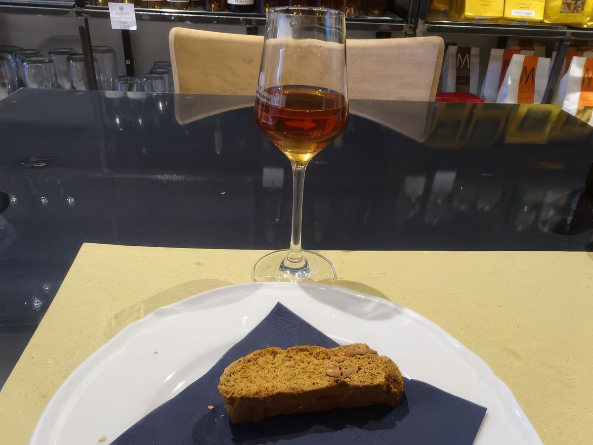 Un verre de malvasia avec un biscuit sec.