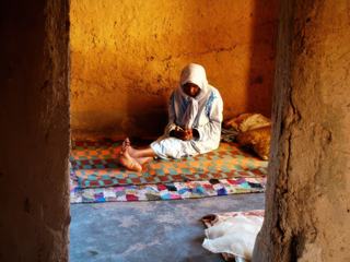 Rituel journalier pour cette femme âgée dans un village reculé au sud du Maroc, en toute sérénité.