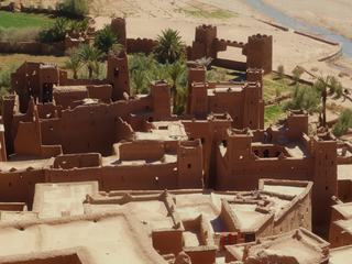 Ksar d'Aït-Benhaddou, au Maroc. On a tendance à entendre aussi le terme de Kasbah, pourtant Aït-Benhaddou est bien un Ksar : c'est à dire un groupement collectif de "maisons" ou "cellules" familiales appelées Kasbah, à l'intérieur de fortifications.
Ce site est inscrit depuis 1987 au patrimoine mondial de l'Unesco. Les chercheurs ne sont pas d'accord quand à la date de construction, entre le VIII et le XIIième siècle a priori. A la base, une trentaine de familles y vivait, mais désormais, seule une dizaine y habite toujours. Les autres ont rejoint l'autre rive et le nouveau village.
Ce site magnifique est également un lieu privilégié pour le tournage de film :les diamants du Nil, Lawrence d'Arabie, Gladiateur, Astérix et Obélix mission Cléopâtre,...
J'ai choisi ce point de vue qui ne montre pas le Ksar dans son intégralité, mais permet de visualiser 2 kasbash en assez bon état sur la droite, d'autres plus abîmées sur la gauche(à cause des fortes intempéries), et les toits-terrasse au premier plan, caractéristiques de ce genre d'habitations.
Bref, un lieu du Maroc à ne pas manquer ;o)