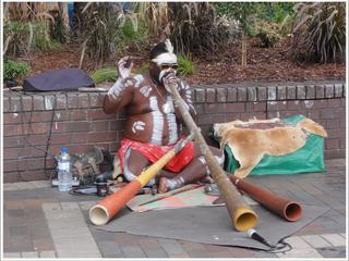 Sur le Circular Quay, à Sydney (Australie), un aborigène joue du didgeridoo pour le plus grand bonheur des touristes. Cependant, l'usage de cette sorte de trompe en bois, qui émet un son si particulier,  pourrait remonter à plus de 20 000 ans d'après les peintures rupestres.
Il est fabriqué avec un tronc d'eucalyptus qui a été creusé dans sa longueur par des termites. Symbole de la culture aborigène, il en existe différents modèles selon les ethnies.