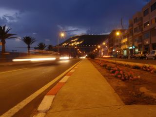 Crépuscule d'une rue d'Agadir, menant à l'ancienne kasbah construite en 1540, sur la colline,surplombant la ville à 236 mètres est inscrit en lettre de feu et en arabe "Dieu Patrie Roi". 
Maroc.