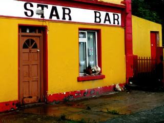 C'est le "Lucky Star Bar", sur Inishmore, la plus grande des îles l'Aran, à l'ouest de l'Irlande.
Il est un peu décrépi, l'est sans doute encore plus aujourd'hui, et pour cause : il est fermé. Témoin de la difficulté à demeurer vivre sur ces îles, rudes et âpres. Ce sont celles des fameux pulls irlandais, aux belles torsades, toutes uniques, car les femmes des marins qui vivaient là les tricotaient tous différents, cela pour pouvoir reconnaître les corps de ceux que la mer prenait, parfois, et rejetait...
On imagine bien que ce bar pouvait être un lieu convivial, tout simple, au retour de dures sorties en mer.