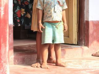 Scène vie prise au vif à Raghuraj Pur en Inde. Ce petit village se visite en peu de temps et tous les habitants sont contents de pouvoir vous vendre leurs objets faits maison. 
C'était l'heure du déjeuner et mon estomac commençait à me parler sérieusement.
Ces deux enfants avaient commencé à déjeuner, mais l'arrivée de touristes était très importante.