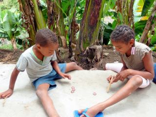 Les enfants capverdiens s'amusent souvent avec pas grand chose... Ces deux-là, frère et sœur, ont inventé leur propre jeu, bien à l'ombre au pied des bananiers, avec des capsules de bouteilles de bière. Peut-être bien celles que nous avons bu pour nous "déssoiffer" après quelques heures de randonnée et lors d'un arrêt pour déjeuner dans ce hameau de Santo-Antao - Mai 2011