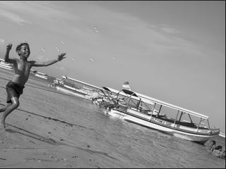 Des bulles de savon font la joie de cet enfant sur une plage de Bali