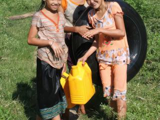 Rencontre avec de petites filles au Laos, près de Vieng Thong, 2011. Après s'être baignées, elles rentraient, chargées d'un bidon d'eau.