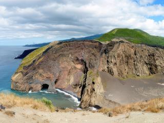 Ici s'est produite de 1957 à 1958 une longue éruption sous-marine côtière, celle du volcan Los Capelhinos, qui a remodelé le paysage et a fait "reculer" le phare (à droite) qui marque l'ancienne position du rivage.
J'aime dans cet archipel la douce énergie qu'on y ressent, les bubons que forment les vieux volcans endormis, reverdis, en  contraste avec les roches dénudées, fracassées récemment, le ciel changeant d'un instant à l'autre, l'Atlantique qui les berce tantôt en gris, tantôt en bleu... Nous sommes aux Açores, sur l'île de Faial.