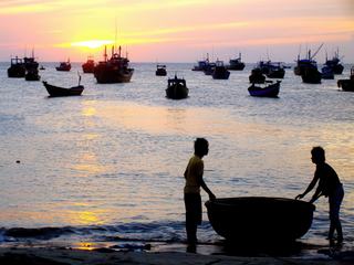 Vietnam (PHAN THIET) mer de Chine méridionale. Au premier plan un bateau coquille de noix départ pour la pêche "Les thuyen thúng, bateaux-paniers en bambou tressé "