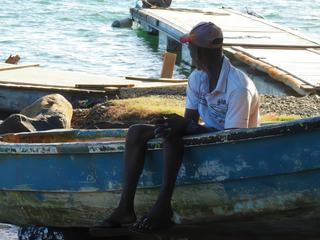 Sainte-Rose sur Basse-Terre en Guadeloupe. 
Au bord de l'eau, assis sur sa frêle embarcation, ce pêcheur jette un dernier regard au large avant d'affronter la mer.