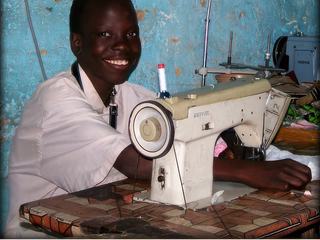 Sénégal - Souk de Kaolack - sourire d'un jeune garçon dans un petit atelier de couture