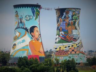 Orlando Power Station dans le quartier de Soweto, est une centrale au charbon déclassée qui a fonctionné de 1933 à 1986, produisant l’électricité pour Johannesburg.
Maintenant désaffectée, certains artistes ont pris d’assaut ces deux tours emblématiques de refroidissement pour en faire de véritables chefs d’œuvre mettant en valeur les symboles de l’Afrique du Sud dont le visage de Mandela...
Il s'agit de la plus grande peinture murale en Afrique du Sud.
Pendant qu’ils décoraient les murs, l’idée leur est venue : "Pourquoi ne pas faire du saut à élastique ici ?" Après 10 ans de lutte pour obtenir les autorisations, le lieu est maintenant reconnu pour ses sensations fortes ! Le saut s’effectue à 100 mètres de hauteur à l’extérieur ou à l’intérieur des tours et une fois au sol, d’autres activités attendent les plus courageux comme du paintball, des descentes en rappel ou de l’escalade.