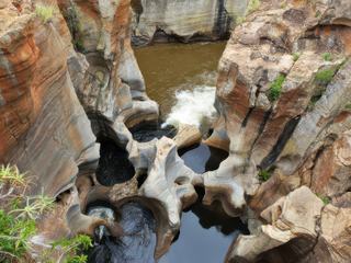 Canyon de la rivière Blyde en Afrique du Sud, les marmites de géants sont un site à ne surtout pas manquer.
Nommées « Bourke’s Luck Potholes », ces formations géologiques aux formes lunaires doivent leurs courbes au confluent des rivières Blyde et Treur. Les violents remous et tourbillons ont érodé la roche, lui conférant cet aspect étonnant. les marmites géantes de Bourke's, constituent l'un des plus beaux exemples de rocs creusés par la force de l'eau et des galets.