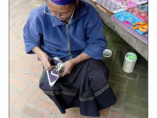 Grand-mère Hmong brodant de jolies pochettes.