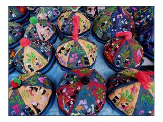 Vente de petits bonnets brodés à la main.