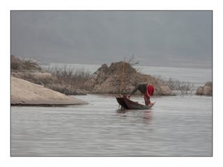Un pêcheur sur sa frêle embarcation.