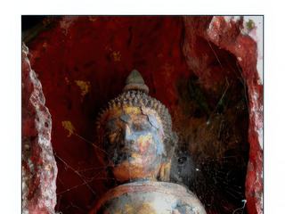 Abrité à l'entrée de la grotte, un petit bouddha veille.