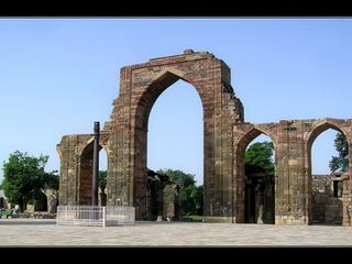 La porte en grés Alai Dawoza et devant sur la gauche le Pilier de Fer, seul élément hindou du complexe laissé intact et érigé au IVe siècle. Il mesure 7 mètres de haut et pèse plus de 6 tonnes.