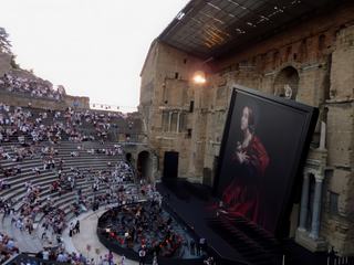 Le superbe mur du Théâtre Antique d'Orange en partie caché par le tableau de Tosca.