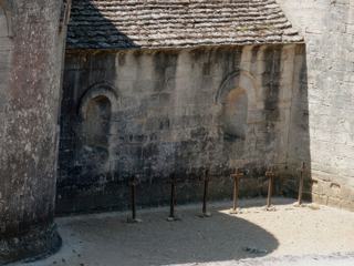 Six moines reposent à même la terre près du chevet de l'église abbatiale.