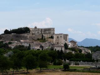 Le château de Grignan, mentionné dès le XIe siècle, occupe un plateau dominant le village installé sur ses pentes dès le Moyen Age. D’abord propriété de la famille de Grignan puis de la famille des Adhémar, le château médiéval est transformé en une prestigieuse demeure de plaisance à la Renaissance, puis au XVIIe siècle, époque où la correspondance de la Marquise de Sévigné évoque l’éclat de cette cour provençale. Ce château, partiellement démantelé pendant la Révolution puis reconstruit au début du XXe siècle, abrite aujourd’hui des collections de mobilier d’art, de peintures et d’étoffes précieuses.