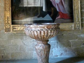 Les fonds baptismaux sont surmontés d'un des principaux trésors de l'église: une rare représentation de la Circoncision du Christ. Il s'agit d'une huile sur bois du XVIe ou XVIIe siècle, due à un peintre méridional d'inspiration flamande qui fait référence au maniérisme italien et nordique. Etait-il destiné à essayer de convertir la nombreuse communauté juive de la ville en leur rappelant cette pratique sacramentelle?