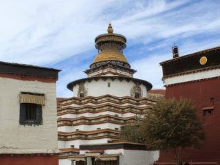 Monastère de Pelkor Chode Un Kumbum est un chorten tibétain de grande taille constituant un bâtiment, comparable à un temple. La base d'un Kumbum regroupe sur plusieurs étages des chapelles abritant des statues de divinités bouddhiques.