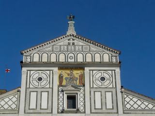 Mosaïque sur fond d'or, du XIIe. siècle, dans laquelle sont rassemblés la Vierge, le Christ et San Miniato. L'aigle d'or de la corporation florentine Calimala trône au sommet. Elle inspira Alberti pour l'achèvement du revêtement des façades de Santa Maria Novella, du Dôme et de Santa Croce.