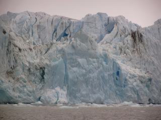 L'eau qui descend de la cordilière entraîne de la terre, d'où les traces noires qu'on aperçoit sur le glacier.
