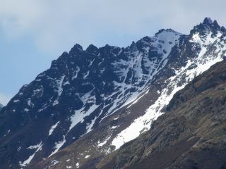 Le canal de Beagle est bordé par deux chaînes parallèles de la cordillère de Darwin, dont les sommets enneigés.