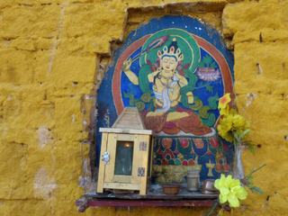 Sur le mur, des petits autels où brûle une petite lampe au beurre de yak.