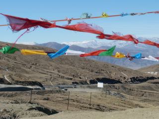 Vue sur la chaine de l'Himalaya à travers les drapeaux de prières.