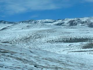 Maintenant nous grimpons de plus en plus et la neige a fait son apparition de chaque côté de la route qu'on aperçoit dans un virage sur la gauche.